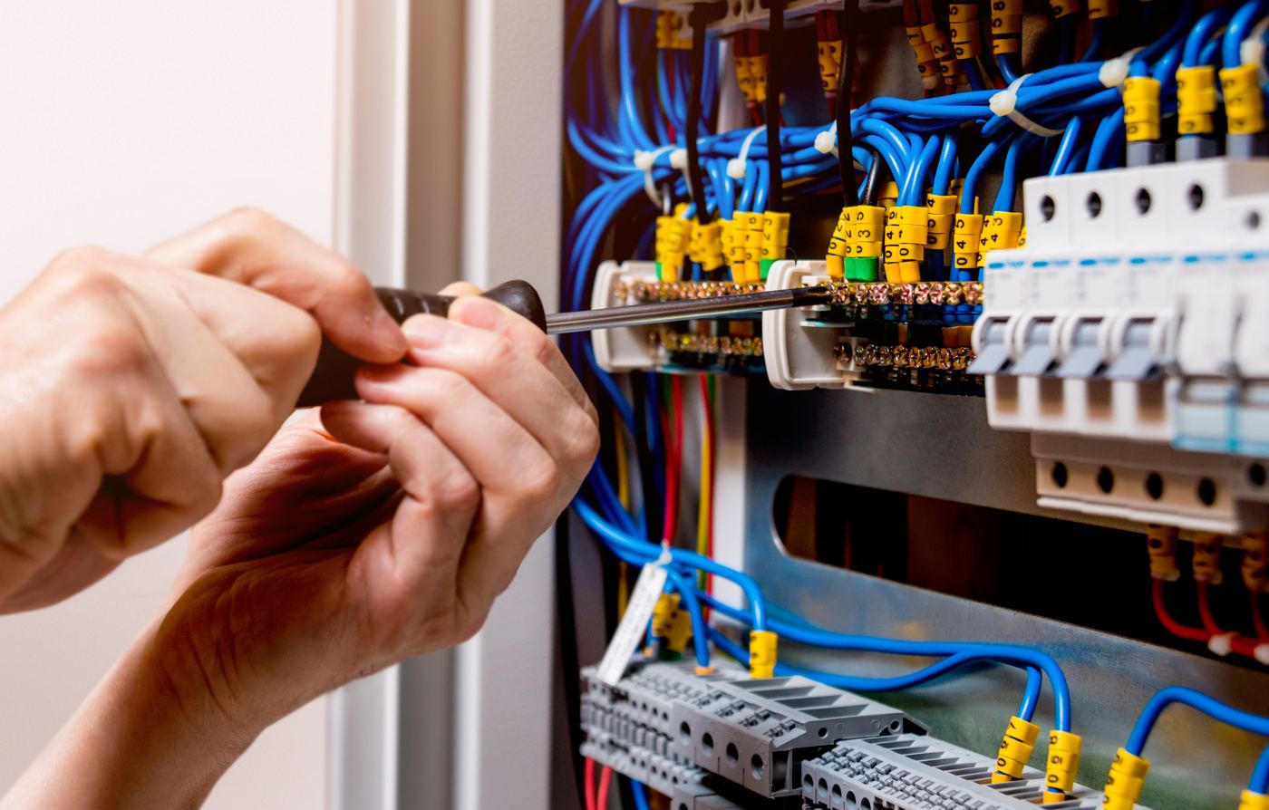 Electrician working on a switchboard with automatic switches